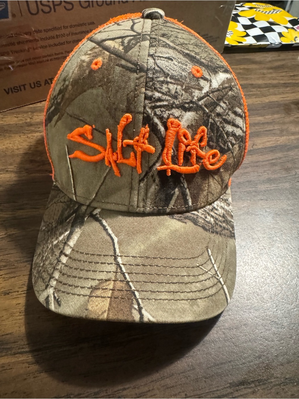 Salt Life camo trucker hat with orange embroidered logo